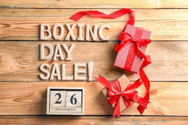 Texte BOXING DAY SALE et coffrets cadeaux sur fond de bois