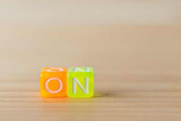 Sur le texte avec des cubes de lettres de couleur sur fond de bois.