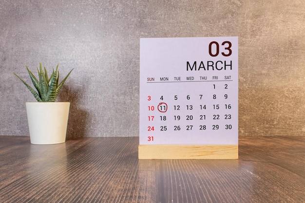 Texte de date du calendrier du 11 avril sur bloc de bois blanc avec papeterie sur bureau en bois