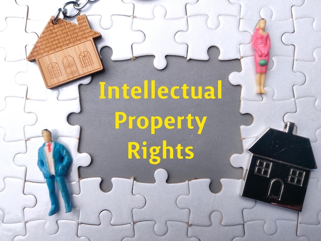 Texte Droits de propriété intellectuelle avec des personnes miniatures et une maison de jouets