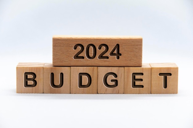 Texte du budget 2024 gravé sur des blocs de bois avec fond de couverture blanche Concept d'entreprise de budgétisation