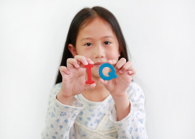 Texte éponge QI (quotient intellectuel) sur les mains d'une fillette sur fond blanc. Concept de développement des enfants et de l'éducation