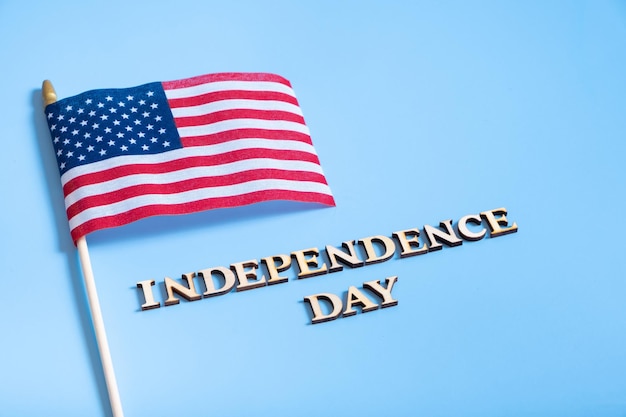 Texte de la fête de l'indépendance avec la vue de dessus des drapeaux américains à plat sur fond blanc