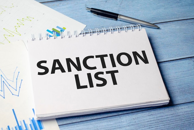 Texte Liste des sanctions sur du papier blanc apposé sur un bloc-notes sur la table