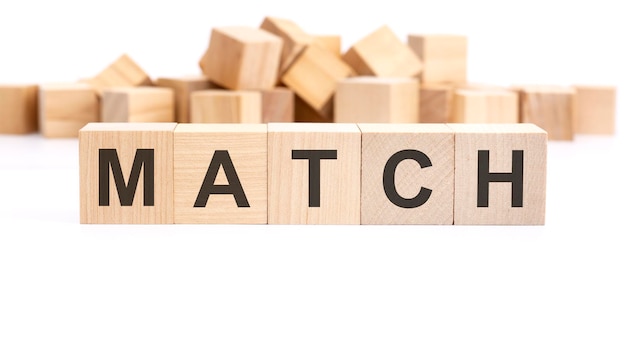 Texte MATCH composé de cubes en bois et de mots différents sur fond blanc