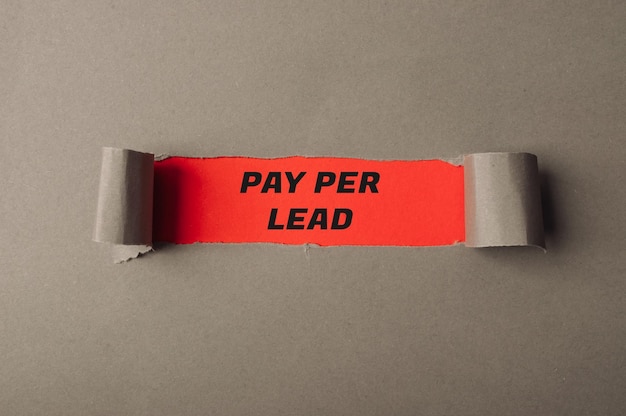 Le texte Pay per Lead est visible à travers un trou dans le papier gris