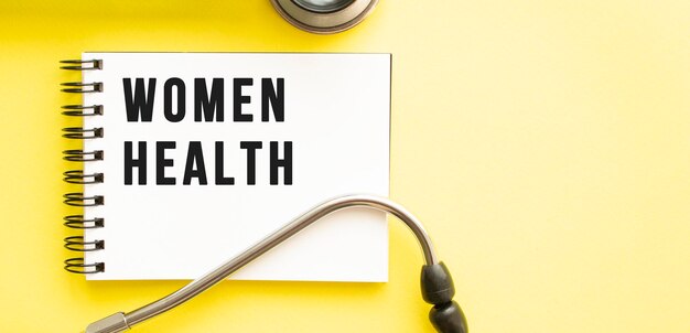 Texte santé des femmes sur ordinateur portable avec stéthoscope sur fond jaune