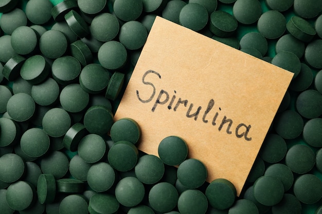 Texte spiruline et pilules sur fond entier