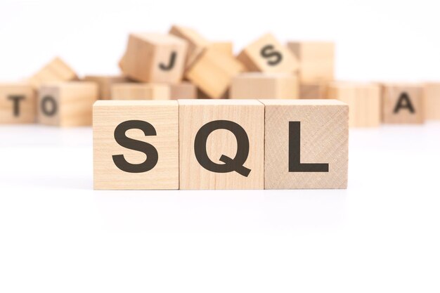 Le texte SQL sales lead qualifié est écrit sur trois cubes en bois debout sur un tableau blanc en arrière-plan une montagne de cubes en bois avec des lettres