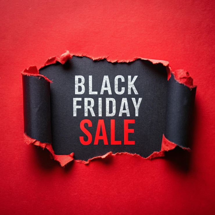 Photo texte de la vente du vendredi noir sur papier déchiré fond rouge réduction de la vente le vendredi noir