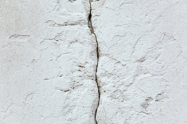 Photo texture et arrière-plan. fissure dans un vieux mur de béton blanc