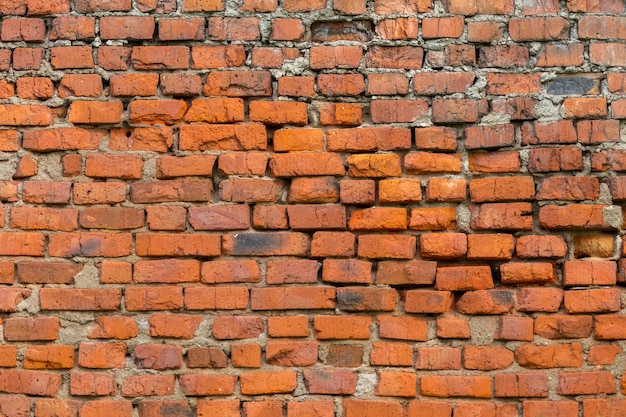 Texture et arrière-plan de mur de briques fortement altérées avec érosion en eau profonde