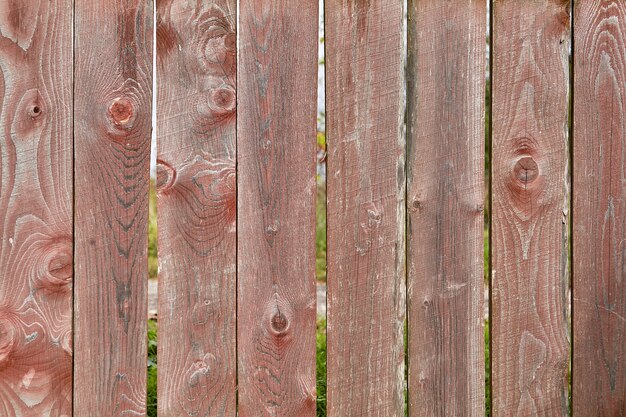 Texture en bois abstraite pour sous la forme d'une vieille clôture patinée avec de la peinture rouge fanée et des déchirures.