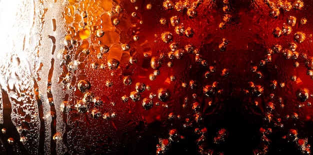 Texture de boisson gazeuse macroVerre de boisson gazeuse avec éclaboussures de glace sur fond sombre Verre de Cola en célébration