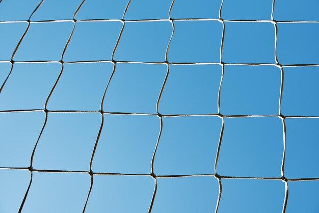 Texture de cage de football ou de football contre le ciel bleu