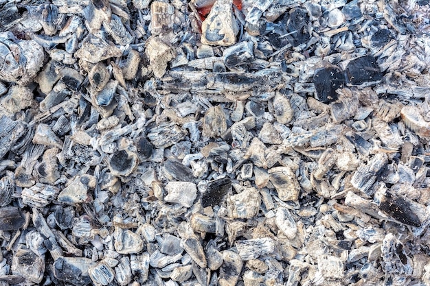 La texture des cendres et des braises d'un feu mourant en plein air comme arrière-plan naturel