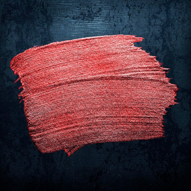 Texture de coup de pinceau de peinture à l'huile rouge métallique sur fond noir