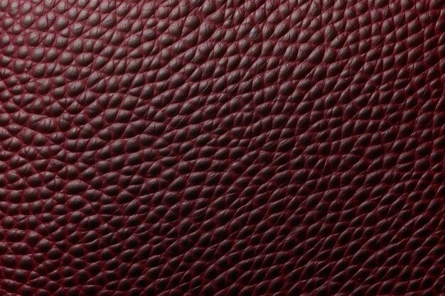 Une texture de cuir rouge avec un motif de serpents dessus.