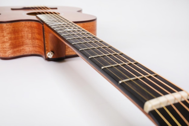 Texture du bois du pont inférieur de la guitare acoustique à six cordes sur la forme de la guitare de fond blanc