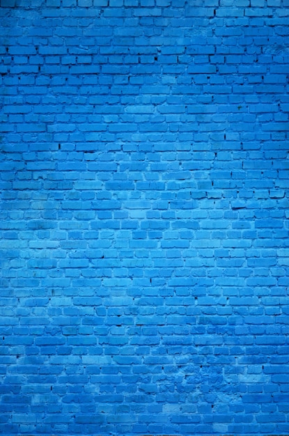 La texture du mur de briques de nombreuses rangées de briques peintes en bleu