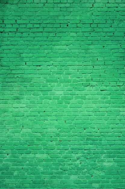 La texture du mur de briques de nombreuses rangées de briques peintes en vert