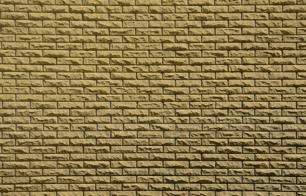 Texture du mur de briques à partir de pierres en relief sous la lumière du soleil