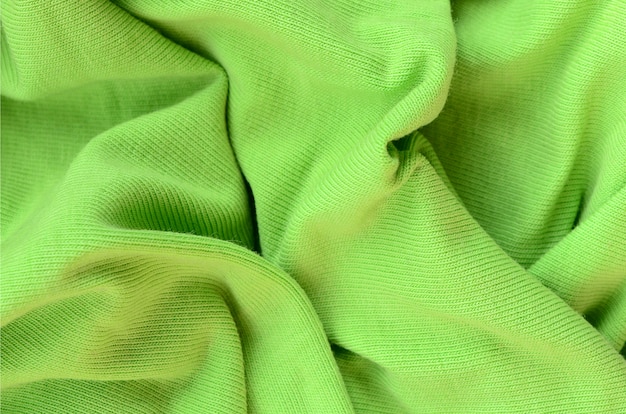 La texture du tissu est vert vif. Matériel pour la confection de chemises et de chemisiers