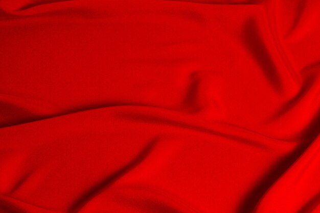 La texture du tissu de luxe en soie rouge ou en satin peut être utilisée comme arrière-plan abstrait. Vue de dessus.