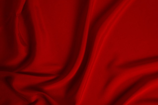 La texture du tissu de luxe en soie rouge ou en satin peut être utilisée comme arrière-plan abstrait. Vue de dessus.