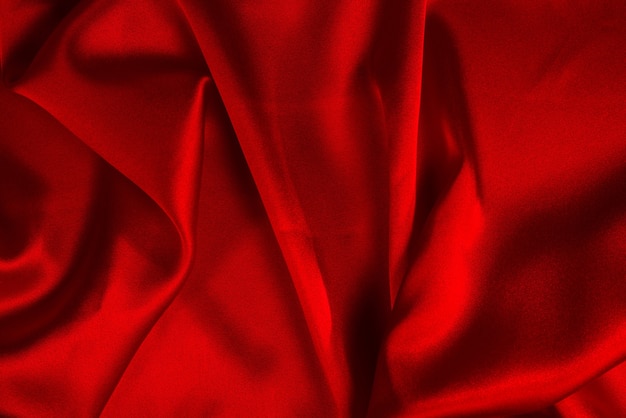 La texture du tissu de luxe en soie rouge ou en satin peut être utilisée comme arrière-plan abstrait. Vue de dessus.