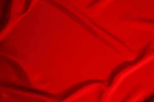 La texture du tissu de luxe en soie rouge ou en satin peut être utilisée comme arrière-plan abstrait. Vue de dessus.