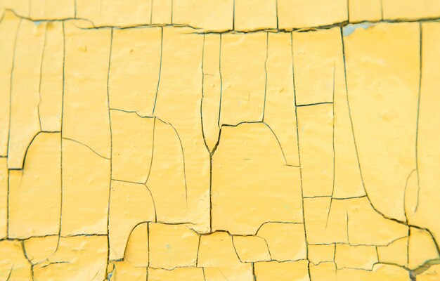 Texture du vieux bois avec de la peinture jaune avec des fissures