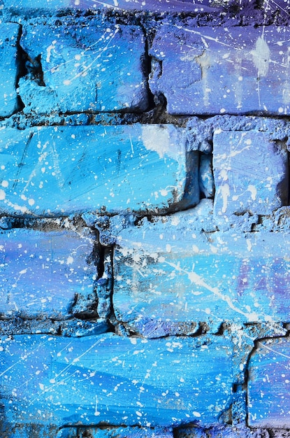 La texture du vieux mur de briques peint en couleurs bleues et violettes avec des gouttes et des éclaboussures blanches négligemment espacées qui visualisent les étoiles dans l'espace