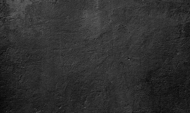 La texture du vieux mur cimente un arrière-plan abstrait noir foncé.