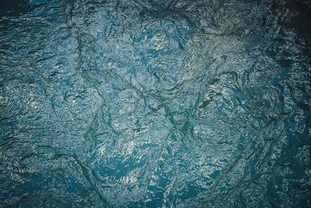 Texture d'eau calme bleu foncé du lac. Ondulations méditatives à la surface de l'eau. Nature fond minimal de lac vert profond. Toile de fond naturelle d'eau turquoise foncée claire. Plein cadre de fragment de lac.