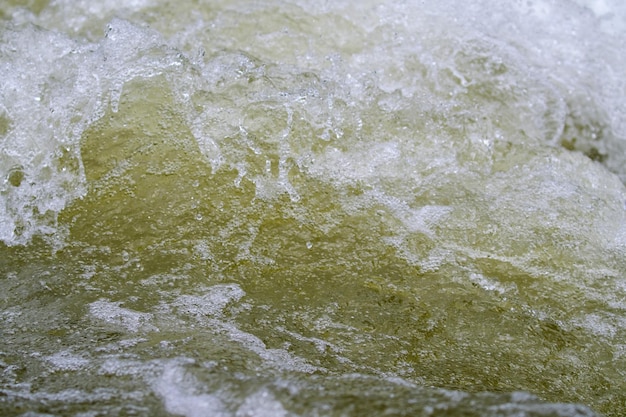 Texture de l'eau à l'état naturel dans une rivière lors des éclaboussures contre les pierres