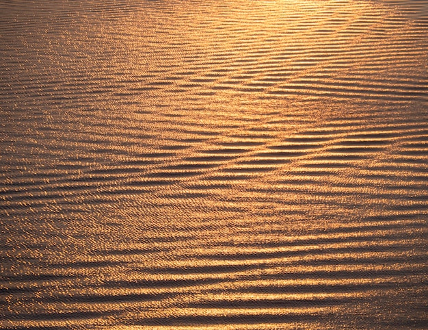 La texture de l'eau de mer et des vagues au coucher du soleil couleurs d'or dans la mer Égée en Grèce