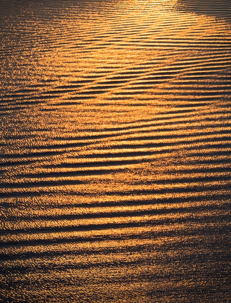 La texture de l'eau de mer et des vagues au coucher du soleil couleurs d'or dans la mer Égée en Grèce