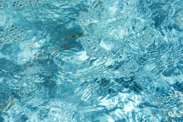 La texture de l'eau de la piscine L'eau bleue transparente brille au soleil Fond naturel abstrait