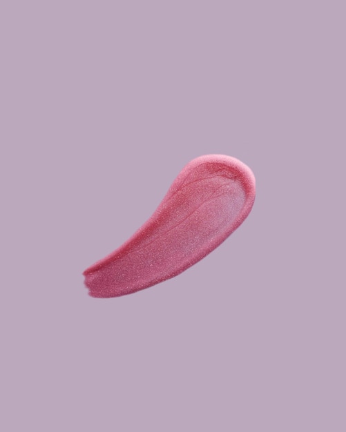 Texture d'échantillon de brillant rouge à lèvres sur fond violet Produit cosmétique taché au rouge à lèvres