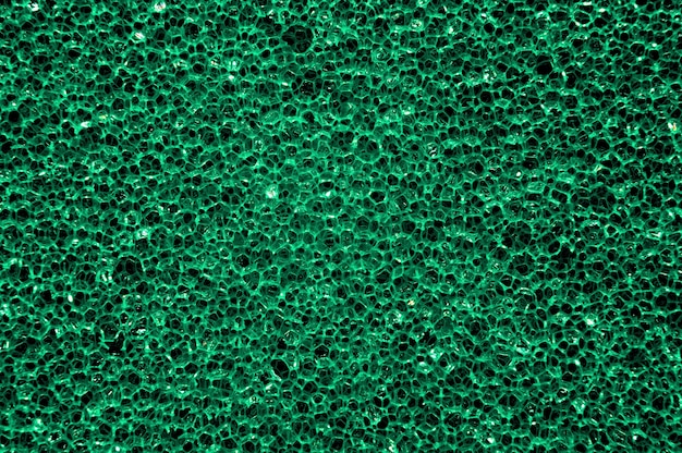 Texture d'une éponge en mousse verte pour laver la vaisselle.