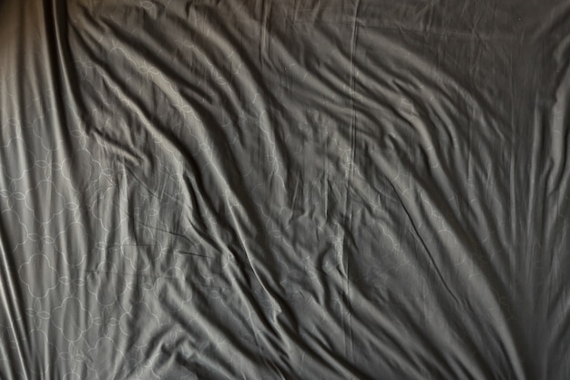 La texture est grise. Drap de lit froissé à motifs.