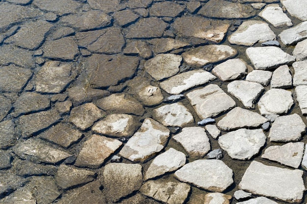 Texture faite par les roches humides du lit de la rivière