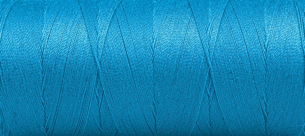 Texture des fils dans une bobine de couleur bleue sur fond blanc