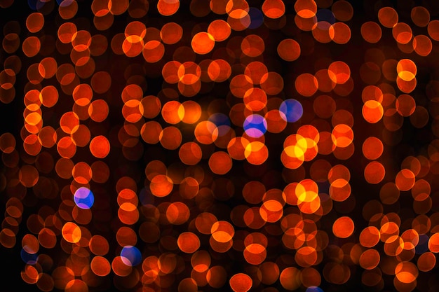 Texture floue abstraite de paillettes d'or, défocalisé de nombreuses lumières de Noël sur fond noir. Concept de Noël de vacances.
