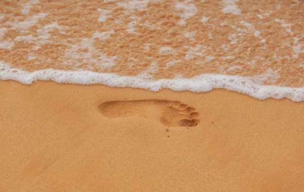 Texture fond empreintes de pieds humains sur le sable sur le sable