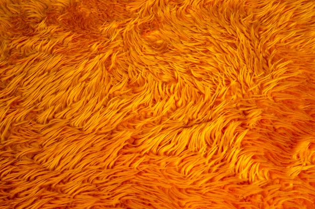 Texture de fond de fourrure orange, gros plan coloré moelleux de laine nature