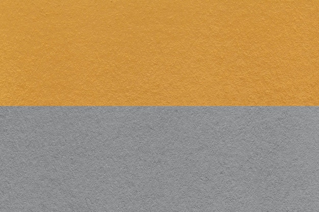 Texture de fond de papier artisanal gris et jaune foncé moitié deux couleurs macro Structure de carton vintage dense ocre Felt fond en gros plan