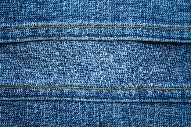 Texture de fond de tissu bleu jeans avec détails de couture