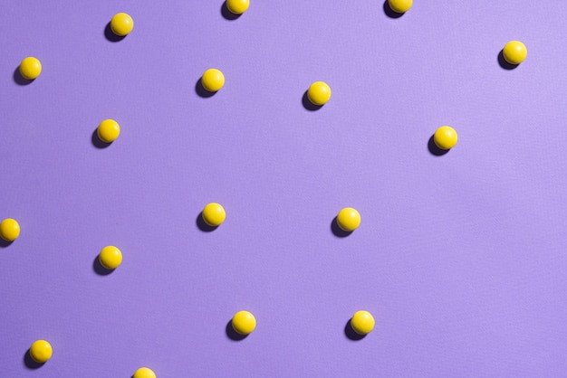 Texture fond violet avec des bonbons au chocolat jaune